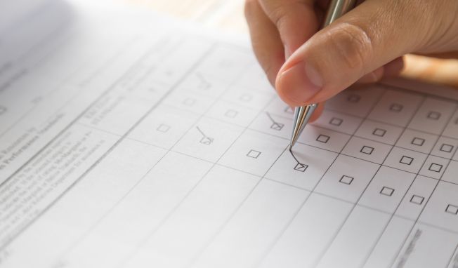 a close-up of a hand ticking an item on a checklist
