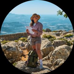 women standing on some rocks overlooking a nice view with a map in hand.