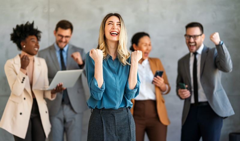 A group of professionals celebrating, focused on a blonde women