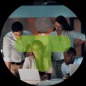 A group of people looking around a table with laptops and documents with a TestMonitor logo on top.