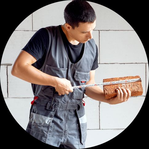 understanding unit testing A builder measuring a brick with a tape measure.