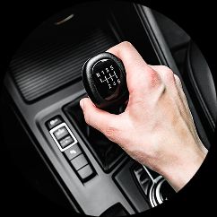 A close-up image of a hand on a manual gear stick in a car.