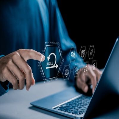 Person at a laptop with agile process icons overlay, illustrating agile testing tools and workflows