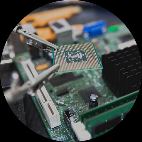 image of a microchip being held by two crocodile clips above a motherboard.