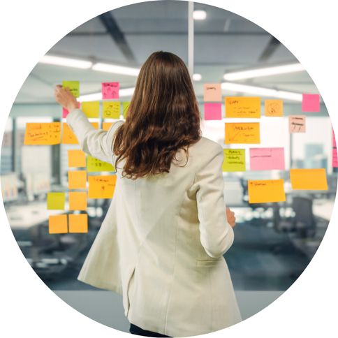 image of a women using post-it-notes on a window to create a plan